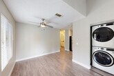 Located at 655 Enterprise Dr in Rohnert Park, CA, this 2-bedroom, 1-bathroom single-floor residence offers a well-planned layout with a cohesive, neutral color palette throughout. The open living room features warm wood-look vinyl flooring, a ceiling fan, and a textured ceiling, creating a comfortable and functional gathering space. Adjacent to the living area, a conveniently located laundry closet houses a stacked washer and dryer unit. The combined kitchen and dining area is outfitted with white shaker-style cabinetry, grey countertops, stainless steel appliances including a gas range and dishwasher, and a range hood — offering a clean, modern aesthetic. Both bedrooms are carpeted and feature neutral grey walls, windows for natural light, and dedicated closets with built-in rods for storage. The primary bedroom includes mirrored sliding closet doors. The full bathroom is finished with wood-look flooring, a white vanity with grey countertop, and a tub/shower combination. A private balcony with wood decking extends the living space outdoors. Additional utility and hallway spaces contribute to the home's practical design. The overall ambiance is clean, move-in ready, and well-suited for comfortable everyday living.