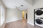 Located at 655 Enterprise Dr in Rohnert Park, CA, this 2-bedroom, 1-bathroom single-floor residence offers a well-planned layout with a cohesive, neutral color palette throughout. The open living room features warm wood-look vinyl flooring, a ceiling fan, and a textured ceiling, creating a comfortable and functional gathering space. Adjacent to the living area, a conveniently located laundry closet houses a stacked washer and dryer unit. The combined kitchen and dining area is outfitted with white shaker-style cabinetry, grey countertops, stainless steel appliances including a gas range and dishwasher, and a range hood — offering a clean, modern aesthetic. Both bedrooms are carpeted and feature neutral grey walls, windows for natural light, and dedicated closets with built-in rods for storage. The primary bedroom includes mirrored sliding closet doors. The full bathroom is finished with wood-look flooring, a white vanity with grey countertop, and a tub/shower combination. A private balcony with wood decking extends the living space outdoors. Additional utility and hallway spaces contribute to the home's practical design. The overall ambiance is clean, move-in ready, and well-suited for comfortable everyday living.