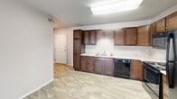 This single-floor unit offers a practical and cohesive layout designed for comfortable everyday living. The kitchen serves as a functional centerpiece, featuring rich dark wood cabinetry extending from floor to ceiling, light-toned countertops, and a full suite of black appliances including a refrigerator, electric range, over-the-range microwave, and dishwasher. Light stone-look tile flooring runs throughout the kitchen and connects seamlessly to the adjacent living areas, enhancing the open feel of the space.

The bedrooms are finished with plush carpeting and neutral-toned walls, providing a calm and restful atmosphere. One bedroom benefits from a walk-in closet equipped with wire shelving and hanging rods, offering ample organized storage. Natural light enters through standard windows fitted with blinds, and baseboard heating is present in the living areas.

Two full bathrooms are included, each featuring wood-tone vanities with light granite-style countertops, tile flooring, and a tub-shower combination. A dedicated laundry room with full-size washer and dryer hookups—and units included—adds everyday convenience. Throughout the unit, a consistent neutral color palette and clean finishes create a tidy, move-in-ready environment.