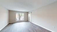 Located at 601 Northpointe Pky in Jackson, Mississippi, this single-floor unit offers a well-organized layout with a clean, neutral aesthetic throughout. The entryway greets visitors with warm wood-look flooring that extends through the main living areas, complemented by crisp white trim and soft beige walls. A built-in open shelving unit near the front door adds a functional and decorative touch to the entry space.

The open living area is bright and airy, benefiting from a large picture window that frames outdoor greenery and a sliding glass door fitted with vertical blinds, allowing for flexible light control. A textured popcorn ceiling adds a classic finish overhead, while recessed ceiling fans provide comfort throughout.

The kitchen features rich, warm-toned wood cabinetry, granite-look countertops, a stainless steel sink, and black appliances. The wood-look flooring continues seamlessly into this space, reinforcing a cohesive design throughout the common areas.

The bedroom transitions to plush wall-to-wall carpeting, creating a comfortable retreat. It connects directly to a hallway that leads to the bathroom, which is outfitted with wood-look flooring, a full tub-shower combination, chrome fixtures, and grab bars for added convenience. The overall layout is practical and well-appointed for everyday living.