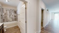 Located at 219 Philema Rd. in Albany, GA, this well-appointed single-story home offers 2 bedrooms and 2 bathrooms with a thoughtfully designed layout. The open-concept kitchen and living area serves as the heart of the home, featuring sleek gray shaker cabinets with gold hardware, quartz countertops, a center island, white subway tile backsplash, and a full suite of stainless steel appliances. Globe pendant lighting adds a modern touch overhead. The living room is bright and airy, with wood-look luxury vinyl flooring, a ceiling fan, and large sliding glass doors that flood the space with natural light and provide access to the outdoors. Both bedrooms are carpeted and comfortably sized, each with a dedicated closet. The primary bedroom features a generous walk-in closet with built-in shelving. The two bathrooms are finished with quartz countertops and striking marble-look tile surrounds on the tub-shower combos. One bathroom showcases navy-blue cabinetry with gold accents and a large mirror, while the second offers a clean, neutral aesthetic with a built-in shower niche. A utility room and two closets round out the functional layout of this move-in ready home.