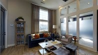 Located at 7505 Worthington Galena Rd in Columbus, Ohio, this thoughtfully designed single-floor space offers a seamless blend of modern sophistication and comfortable living. The interior is immediately distinguished by its impressively tall ceilings, which amplify the sense of openness and allow natural light to flow generously throughout. Large windows dressed with elegantly patterned drapes frame views of the surrounding neighborhood while contributing to the bright, airy atmosphere. The living area is anchored by a deep navy blue sofa accented with warm amber and geometric throw pillows, complemented by a sleek glass and gold coffee table that adds a refined touch. A richly toned area rug grounds the seating arrangement, adding warmth and texture to the space. Adjacent to the main living area, a glass-paneled partition wall creates a subtle division between spaces while maintaining an open, connected feel. Neutral warm-gray walls serve as a versatile backdrop, allowing the carefully curated furnishings and accent pieces to take center stage. The overall ambiance is polished yet inviting, making this space well-suited for both relaxed everyday use and stylish entertaining. A built-in bookcase adds character and functional display space, rounding out the cohesive and well-appointed interior.
