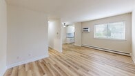 Located at 17 W Vine St in Pottstown, PA, this two-bedroom, one-bathroom unit offers a well-organized single-floor layout designed for comfortable everyday living. The open living room and kitchen area is anchored by light hardwood flooring that runs throughout the main living spaces, creating a bright and cohesive feel. A ceiling fan adds comfort to the combined living and kitchen area, which is illuminated by natural light from a window with blinds. The kitchen is efficiently designed in a galley style, featuring crisp white shaker cabinets, dark granite countertops with a subway tile backsplash, a stainless steel sink, and a full suite of stainless steel appliances including a refrigerator, range, and microwave. Both bedrooms are carpeted and offer a quiet, comfortable retreat, each equipped with individual wall-unit air conditioning and baseboard heating. The primary bedroom is generously proportioned and includes its own window for natural light. The second bedroom features a double sliding-door closet, providing ample storage. The bathroom is finished with neutral beige tile on both the floors and walls, a tub/shower combination, and a vanity with a mirror. A dedicated hallway and closet round out this practical and move-in-ready home.