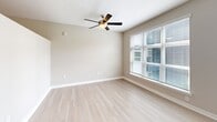 Located at 2509 N Davidson St in Charlotte's vibrant NoDa arts district, this single-floor, one-bedroom, one-bathroom unit offers a thoughtfully designed layout with contemporary finishes throughout. The open kitchen and living area is anchored by a sleek galley-style kitchen featuring white cabinetry with modern hardware, quartz countertops, a stainless steel undermount sink with a pull-down faucet, a stainless steel side-by-side refrigerator, and a dishwasher. Light wood-style flooring runs throughout the main living areas, lending a clean, cohesive aesthetic. Natural light flows in through large windows dressed with horizontal blinds. The bedroom offers a comfortable, carpeted retreat with a ceiling fan and a sizable window that brings in additional natural light. Storage is addressed with wire shelving in the closet area. The bathroom is cleanly finished with light tile flooring, a white vanity with ample drawer storage, a tub-shower combination with marble-style tile surround, and recessed lighting. A dedicated in-unit laundry area adds everyday convenience. The unit's neutral color palette and modern design create a bright, welcoming atmosphere throughout.