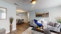 Located at 1100 Willow Springs Rd in Killeen, Texas, this single-story home offers a well-designed layout with a cohesive, contemporary aesthetic. Soft blue-gray walls and durable wood-style flooring run throughout, creating a consistent and inviting atmosphere across all rooms.

The living room is a comfortable, light-filled space featuring a ceiling fan, large windows with patterned curtains, and ample room for seating and entertainment. It flows naturally into the dining area, which is accented by a pendant light and offers an intimate setting for meals.

The galley-style kitchen is efficiently designed with white cabinetry, dark countertops, a classic white subway tile backsplash, and stainless steel appliances including a range, microwave, refrigerator, and dishwasher.

The home includes two bedrooms, each equipped with a ceiling fan and windows that allow natural light to filter in. The primary bedroom provides generous space, while the secondary bedroom offers a cozy and functional layout suitable for a variety of uses.

The bathroom features marble-style tile flooring, a white vanity with dark countertop, a wide mirror, and a tub-shower combination, combining practicality with a clean, modern look throughout.