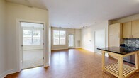 This 2-bedroom, 2-bathroom unit at 5640 Infinity Ln in Virginia Beach, Virginia offers a well-designed, single-floor layout that makes efficient use of its space. The open-concept living, dining, and kitchen area serves as the heart of the home, featuring warm wood-style flooring that flows throughout the main living spaces. Large windows allow generous natural light to fill the room, creating a bright and airy atmosphere, while a glass-panel door provides direct access to the outdoors.

The kitchen is thoughtfully appointed with light maple cabinetry, dark granite-style countertops, a mosaic tile backsplash, and a full suite of stainless steel appliances including a refrigerator, oven, microwave, and dishwasher. A kitchen island provides additional prep and dining space.

Both bedrooms are carpeted for comfort and feature neutral wall tones. The secondary bedroom includes a built-in shelving unit and a window with an outdoor view. Each bedroom is supported by its own dedicated bathroom — one featuring a soaking tub and vanity with wood-toned cabinetry, and the other offering a walk-in shower. Two closets provide practical storage throughout the unit. Track lighting accents the living area, completing a clean and functional design.
