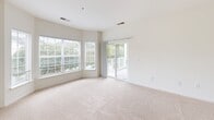 Located at 1000 Marley Manor Dr in Salisbury, Maryland, this single-floor residence offers a clean, bright, and well-organized layout designed for comfortable everyday living. The interior is finished throughout with neutral tones and plush wall-to-wall carpeting in the living and bedroom areas, creating a warm and cohesive atmosphere.

The spacious living room is a standout feature, benefiting from an abundance of natural light through large windows and a sliding glass door that opens onto a private balcony overlooking the surrounding greenery. This seamless indoor-outdoor connection enhances the overall sense of openness.

The kitchen is functionally designed with warm wood cabinetry, light countertops, and a full suite of black appliances including a refrigerator, range, dishwasher, and over-the-range microwave. A peninsula provides additional prep and seating space, while light wood-style flooring adds a clean, practical finish.

The bedrooms are generously sized with neutral carpeting and ample natural light. One bedroom includes direct access to a walk-in closet with built-in shelving, as well as an en-suite bathroom featuring a soaking tub and wood-style flooring. An additional full bathroom with a tub-shower combination serves the rest of the home. Six-panel doors with brass hardware are consistent throughout, contributing to a unified design aesthetic.