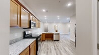 Located at 4229 Mel Smith Rd in New Albany, Indiana, this single-floor home offers a well-designed, open-concept layout with consistent, modern finishes throughout. The kitchen serves as the heart of the home, showcasing warm honey-toned cabinetry, granite countertops, a full suite of stainless steel appliances including a range, microwave, dishwasher, and refrigerator, and a generous peninsula with a built-in sink — ideal for both meal prep and casual dining. Light wood-look luxury vinyl plank flooring runs throughout the main living areas, creating a cohesive and easy-to-maintain foundation. The bedrooms are carpeted for comfort and feature large windows that invite natural light, with the primary bedroom including a ceiling fan and direct access to an en-suite bath. The primary bath is appointed with granite countertops and a full tub-shower combo. A spacious walk-in closet with wire shelving provides ample storage. An additional room with wood-look flooring offers flexibility as a bedroom, office, or flex space, with its own closet access. The dedicated laundry room includes a full-size washer and dryer. Neutral wall tones and clean white trim give the entire home a fresh, move-in-ready feel.
