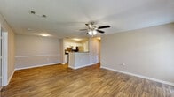 This single-story, 3-bedroom, 2-bathroom home in Covington, GA offers a well-designed layout with a comfortable blend of functionality and style. The open living room greets you with rich hardwood-style flooring, a ceiling fan with light fixture, and multiple windows that fill the space with natural light, along with a door providing direct exterior access. The galley-style kitchen is well-appointed with white cabinetry, stainless steel appliances including a refrigerator and dishwasher, a black electric range, tile backsplash, and ample counter space — all set on warm wood-look flooring. The primary bedroom is a comfortable retreat featuring plush carpeting, a ceiling fan, and an en-suite bathroom with convenient access. All three bedrooms are carpeted and equipped with ceiling fans, offering a consistent, cozy feel. The three closets throughout the home — including a generously sized walk-in with wire shelving — provide substantial storage. Both bathrooms are finished with wood-look flooring, white vanity cabinetry, and a tub-shower combination with tiled surround. Neutral tones and clean finishes throughout give this home a move-in-ready appeal.