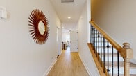 Located in Charlotte, NC, this two-story home offers a well-designed layout spread across two levels. The main floor features light wood flooring throughout, connecting a welcoming hallway — accented by a decorative sunburst mirror and a wood-and-iron staircase — to the open-concept kitchen, dining, and living areas. The kitchen is outfitted with gray shaker cabinets, granite countertops, stainless steel appliances, and a central island with a built-in sink. The dining area opens to the outside through French doors, filling the space with natural light, while the living room features a ceiling fan and large windows. A dedicated office on this level offers carpeted flooring and a bright window, ideal for working from home. Upstairs, the spacious primary bedroom includes a walk-in closet with built-in shelving and an en-suite bathroom featuring granite vanity countertops, gray cabinetry, and a glass-enclosed shower. The second bedroom is bright and carpeted, bathed in natural sunlight. Additional bathrooms throughout feature consistent granite countertops and light wood-style flooring. The home maintains a clean, neutral palette with white walls and trim, creating a bright and cohesive ambiance throughout.