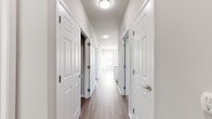 This single-floor residence offers a thoughtfully designed layout that balances comfort and functionality. The living area is finished with smooth hardwood-style flooring and features a bright, airy atmosphere thanks to large windows with blinds that allow natural light to fill the space. A private entry door leads directly into this open area, enhancing accessibility and flow.

The kitchen is outfitted with crisp white cabinetry, granite-style countertops, a classic subway tile backsplash, and a full suite of stainless steel appliances, including a range, over-the-range microwave, and refrigerator — providing a clean, modern aesthetic suited for everyday cooking.

A well-lit hallway with flush-mount ceiling fixtures connects the living areas to the private rooms, each featuring plush wall-to-wall carpeting and ample closet space. Natural light filters into the bedrooms through sizable windows with blinds, creating a calm and restful environment.

The bathrooms are finished with wood-style flooring, extended white vanities with dual sinks, solid-surface countertops, and brushed nickel hardware, offering a clean and refined look. A dedicated laundry closet with a full-size washer and dryer adds everyday convenience. Neutral tones and consistent finishes throughout the space create a cohesive and inviting atmosphere.