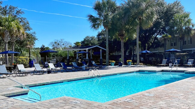 Witness the allure of our radiant resort-style pool, embraced by a tropical landscape offering 'vacation at-home 365' vibes. - Lanier Landing