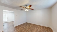 This single-story, 2-bedroom, 1-bathroom unit in Morehead, Kentucky, offers a practical and well-organized layout. Wood-look laminate flooring runs consistently throughout the entire space, providing a cohesive aesthetic. Each room is fitted with a ceiling fan with integrated light kit, contributing both ventilation and ambient lighting.

The living room offers a comfortable amount of space with clean white walls and a textured ceiling. A glass-paneled exterior door allows natural light into the entry area and provides outdoor views. The kitchen features white cabinetry with modern black hardware, white countertops, and a full suite of black appliances including a refrigerator, electric range, microwave, and dishwasher, along with a double basin sink.

Both bedrooms are well-proportioned, each with a window for natural light and a closet for storage. The primary bedroom includes two closets accessible via a hallway. The shared bathroom is accessed through a narrow hallway and includes a single-sink vanity with white cabinetry, a tub-shower combo, and wood-look flooring that matches the rest of the unit. The overall ambiance is clean, neutral, and move-in ready.