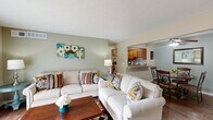 Located at 3825 Fox Run Dr in Blue Ash, Ohio, this single-floor, 2-bedroom, 2-bathroom home offers a thoughtfully designed layout that balances comfort and functionality. The open-concept living area is bathed in natural light from large sliding glass doors fitted with vertical blinds, which lead to an outdoor space. Wood-style flooring flows throughout the main living areas, complementing the soft, neutral wall tones that give the home a warm and inviting ambiance. The living room transitions seamlessly into the dining area, which features a ceiling fan with light fixture, and connects to the kitchen via a convenient pass-through counter. The kitchen includes warm wood cabinetry, granite-style countertops, and ample storage. The generously sized primary bedroom features plush carpeting, a large window with outdoor views, and access to a walk-in closet outfitted with dual wire shelving systems. The second bedroom is equally comfortable with carpeted flooring and closet access. Both bathrooms are well-appointed, with one featuring a full tub-shower combo, wood-toned vanity cabinetry, and wood-style flooring. Throughout the home, textured ceilings, consistent finishes, and a cohesive color palette contribute to a comfortable, move-in-ready living environment.