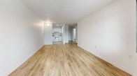 Located at 6880 Boulevard Gouin Est in Montréal, this well-organized one-bedroom, one-bathroom unit offers a practical and comfortable layout across a single floor. Light-toned hardwood flooring runs throughout the main living areas, lending warmth and visual continuity to the space.

The open-concept living area is bright and airy, with large windows that invite natural light and offer views of the surrounding neighbourhood. A sliding door leads to a private balcony, extending the living space outdoors. The kitchen is efficiently designed with white cabinetry and white appliances, seamlessly adjoining the living room for an easy flow between cooking and entertaining areas.

The bedroom is a cozy, well-proportioned room featuring a window with exterior views, a baseboard heater, and a built-in sliding-door closet with gold-toned hardware, providing ample storage. Textured ceilings are consistent throughout the unit.

The bathroom is finished with large-format tile flooring and features a full soaking tub with a white subway tile surround, a curtain rod, and accessibility grab bars. A granite-topped vanity adds a refined touch.

The unit's clean white walls, consistent flooring, and functional design make it a practical and inviting residence in the Montréal-Nord area.