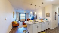 This well-appointed 4-bedroom, 4-bathroom single-floor residence offers a thoughtfully designed open-concept layout that seamlessly connects the kitchen, dining, and living areas. The kitchen is outfitted with white cabinetry, a mosaic tile backsplash, full appliances including a range and built-in microwave, and a generous island with pendant lighting and a double sink — ideal for both cooking and casual dining. The living room features dark hardwood-style flooring, a ceiling fan, and a large window that invites natural light and creates a bright, welcoming atmosphere. Each of the four bedrooms is carpeted, includes a ceiling fan, and benefits from its own private full bathroom — a standout feature for shared or multi-occupant living. The bedrooms are well-lit with large windows and offer comfortable proportions suitable for a bed, workspace, and personal storage. All four bathrooms are consistently finished with white vanities, wood-style flooring, and shower/tub combinations. The cohesive design throughout the unit, with neutral walls and clean finishes, provides a versatile backdrop that accommodates a variety of furnishing styles. This residence is ideally suited for those seeking private, self-contained accommodations within a shared living environment.