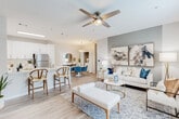 This single-story residence at 913 E Edgefield Dr in Saraland, Alabama, offers a thoughtfully designed open-concept floor plan that seamlessly connects the kitchen, dining, and living areas. Light wood-style flooring runs throughout the main living spaces, complemented by neutral gray-toned walls and ceiling fans that enhance airflow and comfort.

The kitchen is well-appointed with crisp white shaker cabinetry, white quartz countertops, a marble-style tile backsplash, and a full suite of stainless steel appliances. A peninsula with an undermount sink and bar seating provides additional prep and dining space. The adjacent dining area accommodates a round table beneath a modern pendant light, with a built-in storage closet nearby.

The living room features a softly accented accent wall, large framed artwork, and a window allowing natural light. The bedrooms are carpeted for comfort, each with ceiling fans and closet space. The primary bedroom includes an en-suite bathroom, while additional bathrooms offer tub-shower combinations, white vanities with ample counter space, and wood-look flooring. The overall ambiance is clean, contemporary, and move-in ready.