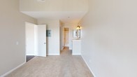 Located in the vibrant Hillcrest neighborhood of San Diego, this single-floor residence on Third Avenue offers a thoughtfully designed layout with stylish finishes throughout. The open living area immediately impresses with soaring vaulted ceilings and rich, dark hardwood flooring that extends seamlessly into the dining and kitchen areas. A corner fireplace with a classic surround serves as a focal point in the living room, complemented by a large window that invites abundant natural light. The kitchen is well-appointed with granite countertops, crisp white cabinetry with elegant hardware, a dishwasher, and a stainless steel refrigerator, all centered around a convenient peninsula. The bedrooms feature plush carpeting and vaulted ceilings, with the primary bedroom offering direct access to an outdoor balcony through sliding glass doors, an en-suite vanity area, and a generously sized walk-in closet outfitted with built-in shelving and hanging rods. The bathrooms are clean and functional, each featuring a full tub-shower combination with chrome fixtures and well-lit vanity areas. The overall ambiance is bright and airy, with a neutral palette that provides a versatile canvas throughout the entire residence.