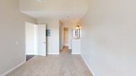Located in the vibrant Hillcrest neighborhood of San Diego, this single-floor residence on Third Avenue offers a thoughtfully designed layout with stylish finishes throughout. The open living area immediately impresses with soaring vaulted ceilings and rich, dark hardwood flooring that extends seamlessly into the dining and kitchen areas. A corner fireplace with a classic surround serves as a focal point in the living room, complemented by a large window that invites abundant natural light. The kitchen is well-appointed with granite countertops, crisp white cabinetry with elegant hardware, a dishwasher, and a stainless steel refrigerator, all centered around a convenient peninsula. The bedrooms feature plush carpeting and vaulted ceilings, with the primary bedroom offering direct access to an outdoor balcony through sliding glass doors, an en-suite vanity area, and a generously sized walk-in closet outfitted with built-in shelving and hanging rods. The bathrooms are clean and functional, each featuring a full tub-shower combination with chrome fixtures and well-lit vanity areas. The overall ambiance is bright and airy, with a neutral palette that provides a versatile canvas throughout the entire residence.