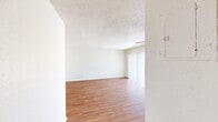 This well-designed apartment in Summit West offers 1050 square feet of living space on a single floor. The layout includes three bedrooms, two bathrooms, a combined kitchen and living room area, and a dedicated laundry room. The primary bedroom is generously sized at 170 square feet, providing ample space for comfort and relaxation.

Throughout the apartment, warm wood-look flooring creates a cohesive and inviting atmosphere. The kitchen stands out with its rich cherry-wood cabinetry, contrasting beautifully with stainless steel appliances and a modern tile backsplash. The bathrooms feature clean white fixtures and tiling, with one bathroom showcasing a spacious walk-in shower with safety bars.

Large windows in the bedrooms and living areas allow for plenty of natural light, while ceiling fans help maintain comfortable air circulation. The in-unit laundry room is equipped with full-sized washer and dryer, adding convenience to daily life.

The apartment's neutral color palette and textured ceilings provide a blank canvas for personalization. With its thoughtful design and modern amenities, this Summit West apartment offers a comfortable and functional living space for its residents.