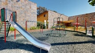 Located at 5242 Pendleton Ave in South Gate, California, this single-level outdoor community space is thoughtfully designed to serve as a central gathering hub. The grounds are anchored by a well-equipped playground area featuring a metal slide, a colorful spiral climbing structure, and swing bars, all set over a gravel safety surface that provides ample room for active play. A low green and yellow perimeter fence defines the playground boundary, ensuring a safe environment for children.

Adjacent to the play area is a paved patio zone furnished with picnic tables and shaded by vibrant umbrella canopies in pink, red, and orange, creating an inviting spot for outdoor dining and socializing. A BBQ grill station is also present, making the space well-suited for community gatherings and events. Raised wooden planter beds with greenery add a natural, welcoming touch to the hardscape surroundings.

The space is framed by striking stone-clad walls in warm earthy tones, complementing the yellow-painted multistory buildings visible in the background. Mature palm trees and shade trees rise throughout the grounds, enhancing the open-air California atmosphere. The entire area benefits from abundant natural sunlight, characteristic of the Southern California climate, making it a bright and functional outdoor amenity space.