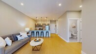 Located at 271-277 State St in Schenectady, NY, this thoughtfully designed one-bedroom, one-bathroom residence offers a well-planned layout across a single floor. The open-concept kitchen and living area serves as the heart of the home, where a large center island with striking granite countertops and seating for multiple bar stools creates an ideal space for dining and entertaining. The kitchen features gray shaker-style cabinetry, a classic white subway tile backsplash, and a full suite of stainless steel appliances, all illuminated by stylish pendant lighting. Light-toned hardwood-style flooring flows throughout the main living area, enhancing the bright and airy feel. The living room is generously sized, offering recessed lighting and sliding glass doors that open to a private balcony, filling the space with natural light. The bedroom is a comfortable retreat finished with plush carpeting, a large window with outdoor views, and ample room to furnish. The bathroom features tile flooring, a tub-shower combination with a curved rod, and clean, neutral finishes. Additional spaces include a utility room and a dedicated closet, providing practical storage solutions throughout this well-appointed residence.