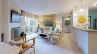 Located at 2502 Manor Dr in Fredericksburg, Virginia, this thoughtfully designed single-floor residence offers a cohesive blend of comfort and contemporary style throughout its living spaces. The open living room is bright and welcoming, featuring large sliding glass doors that flood the area with natural light and provide direct access to a private balcony with outdoor views. A dedicated in-unit laundry area with a full-size washer and dryer adds everyday convenience. The kitchen is well-equipped with stainless steel appliances, dark espresso cabinetry, granite-style countertops, and warm hardwood-style flooring, complemented by a bold teal accent wall. The dining area connects seamlessly to the main living space, featuring hardwood-style flooring and a vibrant accent wall that adds character. The residence includes multiple bedrooms, each distinguished by its own design palette — one showcasing soft blue-gray tones with garden views and a dedicated workspace, and another featuring a dramatic navy accent wall with a walk-in closet. Both bathrooms are finished with dark vanity cabinetry, white countertops, and hardwood-style flooring, offering a clean and functional aesthetic throughout. The overall ambiance is modern and inviting.