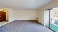 Located at 490 Stamford Dr in Newark, Delaware, this one-bedroom, one-bathroom residence offers a well-organized single-floor layout with a comfortable and functional design. The open-concept kitchen and living area serves as the heart of the home, where a central kitchen island with a light stone-style countertop provides additional workspace and a natural division between the two areas. The kitchen is equipped with dark espresso-toned cabinetry, a white range, microwave, refrigerator, and dishwasher, all set atop wood-look flooring that transitions seamlessly into the carpeted living area. The living room is generously sized, featuring soft carpeting, a ceiling fan, and large sliding glass doors that open to a private balcony, filling the space with natural light and outdoor views. The bedroom offers a comfortable footprint with plush carpeting, a double-door closet for ample storage, and a window that brings in additional natural light. The bathroom features a full tub-shower combination lined with classic white mosaic tile. Throughout the residence, neutral tones and clean finishes create a bright, move-in-ready atmosphere suited to a variety of lifestyles.