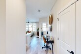 Located on District Lane in Chattanooga, TN, this well-appointed two-bedroom, two-bathroom residence offers a thoughtfully designed single-floor layout with modern finishes throughout. Light wood-style flooring flows through the open-concept living and kitchen areas, creating a seamless and cohesive atmosphere.

The living room is bright and welcoming, featuring a large window dressed with sheer curtains that flood the space with natural light, complemented by a sleek ceiling fan overhead. The kitchen is outfitted with gray cabinetry, stainless steel appliances, white quartz countertops, and a classic subway tile backsplash — a clean and functional space for everyday living.

A hallway leads past a practical workspace nook to the two bedrooms, each finished with plush carpet and generous windows offering outdoor views. The primary bedroom is a comfortable retreat with ample proportions and access to a dedicated closet. The bathrooms are finished with gray vanity cabinetry, white quartz countertops, black matte hardware, and large framed mirrors, conveying a contemporary and polished aesthetic.

Two closets, including a walk-in with built-in shelving, provide practical storage. The overall design balances modern style with everyday functionality, making this Chattanooga residence a refined and comfortable place to call home.