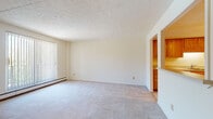 Located at 20123 Lorain Rd in Fairview Park, Ohio, this single-floor residence offers a practical and comfortable layout across a well-organized floor plan. The living area is generously sized, featuring neutral-toned carpet, textured ceilings, and a large sliding glass door with vertical blinds that invite natural light into the space. A baseboard heating system runs along the perimeter, ensuring year-round comfort.

The kitchen is equipped with warm honey-toned cabinetry offering ample storage, a white refrigerator, and an electric range. It connects to the living area via a convenient pass-through window and half-wall, creating an open, communicative flow between spaces.

The bedrooms are carpeted and bright, with one featuring a wall-mounted air conditioning unit and sliding glass door access, while another includes direct access to a bathroom and a walk-in closet. The bathrooms are finished with warm wood vanity cabinetry, white countertops, and tile flooring. One bathroom includes a full tub/shower combination with grab bars, and both feature mirrored medicine cabinets for added storage.

Overall, the space presents a clean, neutral aesthetic with a functional layout well-suited for everyday living in the heart of Fairview Park.
