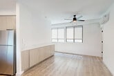 Located at 1740 Van Ness Ave in Fresno, CA, this efficiently designed one-bedroom, one-bathroom unit offers a clean, modern aesthetic with thoughtful use of space across a single floor. Light wood-tone flooring runs throughout, complementing the crisp white walls and creating a bright, cohesive feel.

The open-concept living, dining, and kitchen area is the heart of the unit. The kitchen features light wood cabinetry extending to the ceiling for ample storage, a white quartz peninsula countertop, stainless steel refrigerator, and a black electric range. Recessed and under-cabinet lighting adds a polished finish. Built-in cabinetry along the living area wall provides additional storage, while a ceiling fan and wide windows with roller shades allow for natural light and ventilation. A wall-mounted mini-split unit offers climate control.

The bedroom is a well-proportioned, serene retreat with light wood flooring, a ceiling fan, and a large sliding-door closet with black hardware. The bathroom is clean and functional, featuring wood-look tile flooring, a white pedestal sink, a tiled shower-tub combination, and a mirrored vanity. The entry area is bright and welcoming, with a transom window above the front door adding extra natural light.
