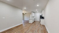 Located at 158 English Commons Dr in Lynchburg, VA, this single-story, 3-bedroom, 2-bathroom home offers a clean, modern design with a thoughtful, functional layout. The open-concept living area seamlessly connects the living room, dining room, and kitchen, all finished with warm hardwood-style luxury vinyl plank flooring and neutral-toned walls that create a bright, welcoming atmosphere. Ceiling fans are present throughout, enhancing comfort in each room. The kitchen features crisp white cabinetry with matte black hardware, light countertops, stainless steel appliances including a range, microwave, and refrigerator, and a peninsula that provides additional prep space and flows naturally into the dining and living areas. A dedicated pantry adds valuable storage. The three bedrooms are carpeted and each equipped with a ceiling fan, providing a cozy retreat. Closets, including a spacious walk-in outfitted with wire shelving, offer generous storage throughout. The bathrooms are finished with hardwood-style flooring, white vanities, and one features a walk-in shower. A dedicated laundry room houses a full-size washer and dryer with overhead wire shelving. The home's consistent, neutral palette and modern finishes give it a cohesive, move-in-ready appeal.