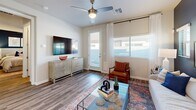 Located in Glendale, Arizona, this single-story 2-bedroom, 3-bathroom residence offers a thoughtfully designed layout with modern finishes throughout. The open-concept kitchen and living area serves as the heart of the home, featuring white shaker cabinetry, white quartz countertops, stainless steel appliances including a dishwasher and refrigerator, and a breakfast bar with seating. Wood-look plank flooring runs throughout the space, adding warmth and continuity.

The living room is bright and inviting, with large windows allowing ample natural light, a ceiling fan, and direct access to an exterior door. A bold navy accent wall adds a striking visual anchor to the space.

The primary bedroom continues the navy accent wall detail, creating a cohesive design story, and includes a ceiling fan and its own en-suite bathroom with dual vanities and a glass-enclosed walk-in shower. The second bedroom is spacious and bright, with its own bathroom access featuring a tub-shower combo and white vanity cabinetry. A dedicated walk-in closet with built-in shelving and multiple hanging rods provides generous storage. A hallway connects all rooms efficiently, completing this well-organized and stylish single-floor residence.