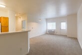 Located at 1501 Almaden Expy in San Jose, CA, this single-floor, one-bedroom, one-bathroom residence offers a practical and well-organized layout. The open-plan living and dining area is bright and airy, featuring neutral carpet flooring, white walls, and a pendant light fixture overhead. Natural light filters in through windows fitted with blinds, offering views of surrounding greenery, while a private entry door provides convenient direct access. A wall-mounted HVAC unit ensures year-round comfort.

The kitchen is separated from the living area by a peninsula counter with a granite-style surface, creating an efficient and semi-open design. Warm-toned wooden cabinetry lines the walls, providing generous storage, and is complemented by white appliances including a gas range, refrigerator, and dishwasher. Wood-look vinyl flooring runs throughout the kitchen and bathroom areas.

The bedroom is a comfortably sized, carpeted retreat featuring clean white walls and a dedicated closet for storage. The full bathroom includes a tub-shower combination, built-in shelving niches, and the same wood-look vinyl flooring, delivering a clean, functional finish throughout. Overall, the space presents a simple, well-maintained interior suited for comfortable everyday living.