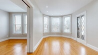 Located in Cincinnati's Grandview neighborhood, this well-appointed 2-bedroom, 1-bathroom residence offers a thoughtfully designed single-floor layout with generous living space. Rich hardwood floors flow throughout, complementing the neutral warm-toned walls and crisp white trim work visible in every room.

The living and dining areas provide an open, airy feel, with the dining space featuring an elegant chandelier and French doors topped by a transom window that open onto one of two outdoor balconies. The balconies offer views of the surrounding urban neighborhood and Cincinnati skyline. The kitchen is outfitted with rich wood cabinetry, glass-front upper cabinets, stainless steel appliances including a gas range and refrigerator, and clean white countertops.

Both bedrooms are bright and comfortable, showcasing distinctive bay window configurations that flood the rooms with natural light and frame outdoor views. The primary bedroom offers exceptional storage with dual closets, while the home overall boasts an impressive seven closets total. The bathroom features marble-look tile flooring, a glass-enclosed shower, and a warm wood vanity. A dedicated laundry room, pantry, and multiple hallways round out this well-organized home, making it as functional as it is charming.