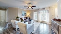 Located at 1825 Grove Point Rd in Savannah, Georgia, this single-floor residence offers a thoughtfully designed layout that balances comfort and functionality throughout. The open-concept living area serves as the heart of the home, featuring crown molding, a ceiling fan, and wood-style flooring that extends seamlessly into the adjacent spaces. A tufted ottoman, leather sofa, and accent seating create a warm, inviting atmosphere, while a breakfast bar connects the living room to the kitchen.

The galley-style kitchen is outfitted with stainless steel appliances, white cabinetry, and generous counter space, providing an efficient and clean cooking environment. Just off the living area, the dedicated dining space features wood-style flooring, elegant pendant lighting, and a circular mirror accent wall that adds depth to the room.

Both bedrooms are carpeted and include ceiling fans and walk-in closets with built-in shelving. Each bedroom benefits from natural light through curtained windows and features neutral, calming tones. The two bathrooms are finished with granite-style countertops, white cabinetry, and full tub-shower combinations. A dedicated in-unit laundry room with a full-size washer and dryer adds everyday convenience to this well-rounded Savannah residence.