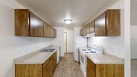 Located in Beaverton, Oregon, this single-floor, two-bedroom, one-bathroom residence offers a practical and comfortable layout across a modest yet efficient footprint. The entrance leads into a well-organized floor plan that connects the key living areas seamlessly.

The galley-style kitchen is a functional highlight, featuring warm wood cabinetry lining both walls, light-toned countertops, wood-look flooring, and white appliances including a range, dishwasher, and refrigerator — providing ample workspace and storage for everyday cooking.

Adjacent to the kitchen, the dining area flows naturally into the living room, which is carpeted and features a charming stone-surround fireplace as its focal point, along with a window that brings in natural light and views of the surrounding greenery. Baseboard heating is present throughout the home.

The primary bedroom is a generously sized retreat with carpet flooring, a window overlooking the outdoors, and a textured ceiling. The second bedroom is equally comfortable, also carpeted and well-lit. Three closets distributed throughout the home provide notable storage capacity.

The bathroom includes a full tub and shower combination with clean white fixtures. Overall, the residence offers a straightforward, livable design with practical features suited for comfortable everyday living in a residential Beaverton neighborhood.