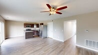 Located at 2575 Gate Dr in Clinton, Iowa, this two-story home offers a well-designed layout spread across two levels. The main floor features an open-concept living and kitchen area with light hardwood-style flooring, creating a bright and welcoming atmosphere. The kitchen is equipped with rich dark wood cabinetry, granite-look countertops, a central island, and a full suite of stainless steel appliances, including a range, microwave, and dishwasher. A ceiling fan anchors the living area, which flows seamlessly from the kitchen. Large windows on the main floor invite natural light and provide views of the surrounding greenery. A carpeted staircase with clean white walls leads to the upper level, which hosts both bedrooms, two closets, two hallways, and two full bathrooms. The generously sized primary bedroom features plush carpeting, a ceiling fan, and a walk-in closet with wire shelving. The second bedroom is equally well-lit with a large window overlooking the outdoors. The bathrooms are finished with dark wood vanities, white countertops, wood-framed mirrors, and light hardwood-style flooring. Throughout, the home maintains a clean, modern aesthetic with neutral tones and practical finishes.