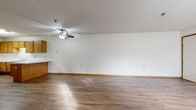 Located at 955 Vadnais Dr in Vadnais Heights, MN, this single-floor, three-bedroom, one-bathroom home offers a practical and comfortable layout. The open living room is a welcoming space featuring warm hardwood-style flooring, a ceiling fan with light fixture, textured ceilings, and neutral white walls with wood-toned baseboards throughout.

The kitchen is well-appointed with abundant warm oak cabinetry providing ample storage, white appliances including a range and refrigerator, a double sink, and light countertops. A peninsula counter connects the kitchen to the living area, creating a functional and social flow between the two spaces.

The three bedrooms feature plush carpeting and natural light from windows with blinds. The primary bedroom is a generously sized retreat, while the additional bedrooms offer closet storage with bi-fold oak doors. Hardwood-style flooring is present in select bedrooms as well.

The bathroom is designed with accessibility in mind, featuring grab bars around the tub-shower combination, an open-concept vanity with a wide mirror, and hardwood-style flooring. The clean, white fixtures and open under-sink design enhance the room's functionality. Overall, the home presents a clean, neutral palette with consistent warm wood accents throughout.