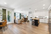 Located in Menifee, California, this well-appointed single-story residence offers three bedrooms and two bathrooms within a thoughtfully designed open floor plan. Light wood-look flooring flows throughout the main living areas, creating a cohesive and airy atmosphere. The kitchen is a standout feature, showcasing bright white cabinetry, stainless steel appliances, subway tile backsplash, and a navy-blue island with a butcher block top and bar seating — ideal for casual dining or entertaining. Adjacent to the kitchen, the combined living and dining area is bathed in natural light from multiple windows dressed with rich green curtains, lending a warm, inviting ambiance. The primary bedroom is generously sized with soft neutral tones and artful wall décor, while the additional bedrooms offer equally comfortable and stylishly appointed spaces. Both bathrooms feature white cabinetry with gray countertops and wood-look flooring; one includes a tiled soaking tub and shower combination. Two closets and a hallway provide practical storage throughout. A private balcony with community views offers an ideal outdoor retreat. The home blends modern finishes with warm, curated design elements for a refined yet livable feel.