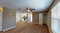 This single-floor, 2-bedroom, 2-bathroom residence in Biloxi, Mississippi presents a well-organized layout designed for comfortable everyday living. The open living area features warm-toned carpeting, neutral walls in earthy beige and gray tones, a textured ceiling, and a ceiling fan with integrated lighting — creating a relaxed, functional atmosphere throughout.

The galley-style kitchen is thoughtfully equipped with white raised-panel cabinetry, granite-look countertops, wood-look tile flooring, and a full suite of stainless steel appliances including a range, microwave, dishwasher, and refrigerator. Ample counter and cabinet space lines both sides of the kitchen, maximizing storage and usability.

Both bedrooms are generously sized with plush carpeting, ceiling fans, and large closets. The primary bedroom benefits from a walk-in closet with built-in shelving, while a separate door provides access to the en-suite bath. Each bedroom is finished with the same consistent neutral palette found throughout the unit.

The two bathrooms are clean and efficiently designed, each featuring tile flooring, a tub-shower combination with a curved curtain rod, a vanity with granite-look countertops, and white cabinetry. The bright, white finishes give both bathrooms a crisp, tidy appearance. Overall, this residence offers a cohesive and practical living environment in a convenient Biloxi location.