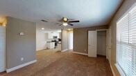 This single-floor, 2-bedroom, 2-bathroom residence in Biloxi, Mississippi presents a well-organized layout designed for comfortable everyday living. The open living area features warm-toned carpeting, neutral walls in earthy beige and gray tones, a textured ceiling, and a ceiling fan with integrated lighting — creating a relaxed, functional atmosphere throughout.

The galley-style kitchen is thoughtfully equipped with white raised-panel cabinetry, granite-look countertops, wood-look tile flooring, and a full suite of stainless steel appliances including a range, microwave, dishwasher, and refrigerator. Ample counter and cabinet space lines both sides of the kitchen, maximizing storage and usability.

Both bedrooms are generously sized with plush carpeting, ceiling fans, and large closets. The primary bedroom benefits from a walk-in closet with built-in shelving, while a separate door provides access to the en-suite bath. Each bedroom is finished with the same consistent neutral palette found throughout the unit.

The two bathrooms are clean and efficiently designed, each featuring tile flooring, a tub-shower combination with a curved curtain rod, a vanity with granite-look countertops, and white cabinetry. The bright, white finishes give both bathrooms a crisp, tidy appearance. Overall, this residence offers a cohesive and practical living environment in a convenient Biloxi location.