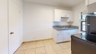 Located at 889 Riverside Dr in Fort Lauderdale, FL, this single-floor, one-bedroom, one-bathroom unit offers a practical and comfortable layout. The combined living and dining area features light-toned ceramic tile flooring, a ceiling fan with integrated lighting, and a window that invites natural light while offering a view of the surrounding greenery. The space flows directly into the kitchen, which is efficiently designed with white shaker-style cabinetry, granite countertops, a stainless steel sink, and black appliances including a refrigerator and electric range with an overhead exhaust. A dedicated window in the kitchen adds additional natural light and ventilation. The bedroom is a generously proportioned retreat finished with plush carpeting, a textured ceiling, and a window that fills the room with soft, natural light. It provides direct access to the full bathroom and features a dedicated walk-in closet, with additional closet storage also available. The bathroom is finished with warm-toned ceramic tile surrounding a full soaking tub and shower combination, accented by chrome fixtures. Throughout the unit, three closets offer exceptional storage capacity. The clean, neutral palette and tile and carpet flooring combination create a bright, easy-to-maintain living environment.