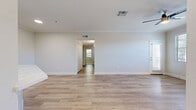 Located in Rancho Cucamonga, CA, this well-appointed unit offers four bedrooms, three bathrooms, and a thoughtfully designed single-level layout. The open-concept living room is anchored by a classic fireplace, light-toned luxury vinyl plank flooring, crown molding, and a ceiling fan, with natural light streaming in through dual windows. The living area flows seamlessly to a private balcony, ideal for outdoor relaxation. The modern kitchen is a standout feature, boasting white shaker cabinetry, quartz countertops, a tile backsplash, stainless steel appliances including a refrigerator, range, and microwave, and a large center island perfect for entertaining. The four bedrooms are carpeted for comfort, each with ceiling fans and windows that bring in ample natural light. Two closets provide generous storage. The three bathrooms are finished with wood-look flooring, white vanities topped with marble-style quartz countertops, and brushed nickel fixtures; one features a full tub-shower combination. Throughout, the neutral color palette and clean finishes create a bright, cohesive aesthetic that is both modern and welcoming.