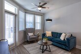 Located at Vintage Preserve Parkway in Houston, TX 77070, this single-story residence offers a thoughtfully designed open-concept layout finished with consistent wood-style flooring across the main living areas. The living room serves as the heart of the unit, featuring a ceiling fan, neutral wall tones, and large windows with blinds that allow ample natural light. A glass-panel exterior door further connects the living space to the outside. The dining area sits adjacent to the living room, creating a seamless flow ideal for everyday living and entertaining.

The kitchen is well-equipped with dark-toned shaker-style cabinetry extending to the ceiling for substantial storage, a white tile backsplash, light stone countertops, and a full suite of stainless steel appliances including a side-by-side refrigerator with ice and water dispenser, electric range, and over-the-range microwave.

Both bedrooms are carpeted and generously sized, each featuring ceiling fans and windows with blinds providing natural light. The primary bedroom connects to a well-appointed en suite bathroom showcasing dark wood cabinetry, granite countertops with an undermount sink, a glass-enclosed walk-in shower with subway tile, and hardwood-style flooring. The layout also includes closet space accessible from the bathroom hallway.