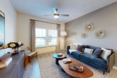 This thoughtfully designed single-floor residence offers a cohesive open-concept layout that seamlessly connects the main living areas. The living room is bright and welcoming, featuring large windows that invite an abundance of natural light, light wood-style flooring, and a ceiling fan overhead. Warm neutral tones on the walls complement the space's contemporary aesthetic.

The kitchen is a standout feature, outfitted with stainless steel appliances including a refrigerator, microwave, and range. Generous granite countertops, white upper cabinetry, and gray lower cabinetry provide both style and ample storage. A peninsula with seating offers a casual dining option beneath pendant lighting, and a classic subway tile backsplash adds a polished finishing touch.

The bedroom is a restful retreat, distinguished by a bold accent wall, plush carpeting, and a well-sized window with drape panels that allow for natural light while maintaining privacy. The bathroom is clean and modern, featuring a granite-topped vanity with gray cabinetry and wood-look tile flooring. A dedicated laundry area with an in-unit washer and dryer adds everyday convenience. Throughout the residence, light wood-style flooring, recessed lighting, and consistent finishes create a unified and inviting atmosphere.