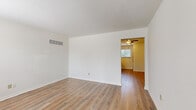 This two-story home offers a practical and well-organized layout across two floors, with the main living areas on the ground level and the bedrooms situated above. The ground floor houses the living room and kitchen, both finished with durable hardwood-style flooring. The living room is an open, bright space with clean white walls and a ceiling vent system, flowing directly into an entrance area with a ceiling fan. The kitchen is equipped with warm honey-toned wood cabinetry, dark granite-style countertops, black appliances including a dishwasher, range, and microwave, along with a ceiling fan and a window that brings in natural light.

Upstairs, the three bedrooms offer a comfortable retreat, each featuring plush carpeting and ample natural light from windows fitted with blinds. The generously sized primary bedroom is notably spacious, while the secondary bedrooms are well-proportioned. Each bedroom is served by closets — some with bifold doors and full-width hanging rods, providing practical storage solutions. The single full bathroom features a clean white tub-shower combination with matte black fixtures. Hallways and staircases connect the floors efficiently, completing this straightforward and functional home layout.