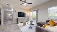 This single-level, 2-bedroom, 2-bathroom residence delivers a clean, modern aesthetic throughout its efficiently designed floor plan. The open-concept living, dining, and kitchen area forms the heart of the home, featuring light wood-look flooring, neutral wall tones, and a ceiling fan that adds both function and style. Sliding glass doors flood the living room with natural light and open directly onto a private balcony, offering pleasant outdoor views. The kitchen is equipped with stainless steel appliances, gray shaker-style cabinetry, a white quartz peninsula with an undermount sink, and a seamless connection to the dining area, which features a glass-top table and easy access to a warm-toned mirror accent. Both bedrooms are carpeted for comfort and feature large windows with outdoor views, allowing abundant natural light. The primary bedroom offers a generous footprint, while the second bedroom provides a cozy, well-proportioned retreat. Each bathroom is finished with tile flooring, a navy-toned vanity with a round mirror, and overhead lighting. A dedicated laundry room with built-in shelving adds everyday convenience. The overall ambiance is modern, bright, and cohesive, with consistent neutral tones and contemporary fixtures throughout.