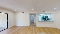 Located in Sunrise, FL, this thoughtfully updated 2-bedroom, 2-bathroom residence offers a clean, modern aesthetic throughout its single-floor layout. Light wood flooring flows seamlessly across the living areas and bedrooms, complementing the crisp white walls and textured ceilings fitted with recessed lighting. The open living room is a standout space, bathed in natural light from large sliding glass doors that lead to a private balcony with outdoor views, creating a bright and airy atmosphere. A pass-through window connects the living area to the kitchen, which features white cabinetry and stainless steel appliances, enhancing the sense of openness. A connecting hallway leads to both bedrooms and bathrooms. The primary bedroom is generously sized, offering a walk-in closet with dual wire shelving systems for ample storage. The second bedroom includes a standard closet and a window that invites natural light. Both bathrooms are finished in a sleek, minimalist style with white tile, matte black fixtures, and modern hardware. One bathroom features a deep soaking tub with an overhead rain shower, while the other showcases a walk-in shower with a square rain showerhead and integrated black controls — both exuding a refined, contemporary feel.