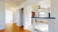 This efficiently designed single-floor unit offers three bedrooms, one bathroom, a living room, kitchen, and two hallways within a compact but well-organized footprint. Warm-toned hardwood flooring runs throughout the majority of the space, lending a cohesive and inviting feel to the living areas and bedrooms.

The kitchen is well-equipped, featuring warm wood cabinetry, dark countertops, stainless steel appliances including a gas range and refrigerator, and light tile flooring. A ceiling fan overhead and a window providing natural light make this an airy, functional cooking space. A peninsula counter connects the kitchen to the adjacent area, adding workspace and a sense of openness.

Each bedroom is simply designed with white walls, hardwood floors, and individual windows that bring in natural outdoor views and ample daylight. Baseboard heating runs along the walls in most rooms. Select bedrooms include sliding-door closets for practical storage, while the primary bedroom also features a separate closet.

The bathroom offers light tile flooring, a tub-shower combination with full tile surround, and a window for natural ventilation. Two hallways connect the rooms efficiently throughout the unit, completing this straightforward and functional layout.